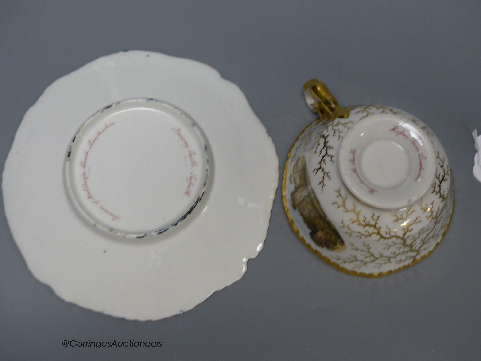 A Flight Barr and Barr gadroon bordered teacup and saucer painted with named landscapes